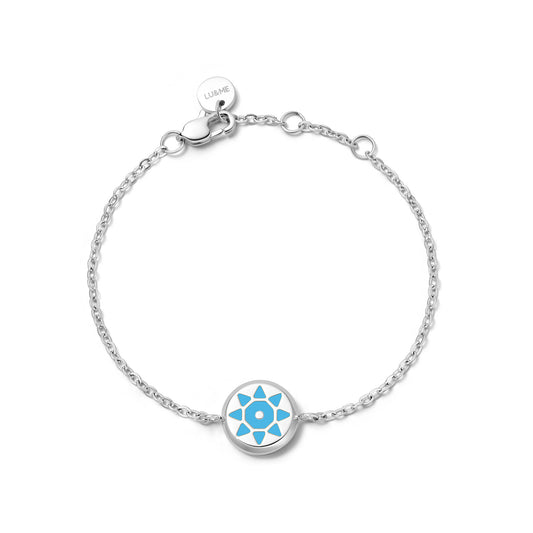 Silver bracelet with a blue embossed circular charm on a silver background