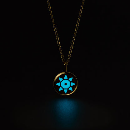 Gold SOLIS necklace with a glowing blue pendant on a black background