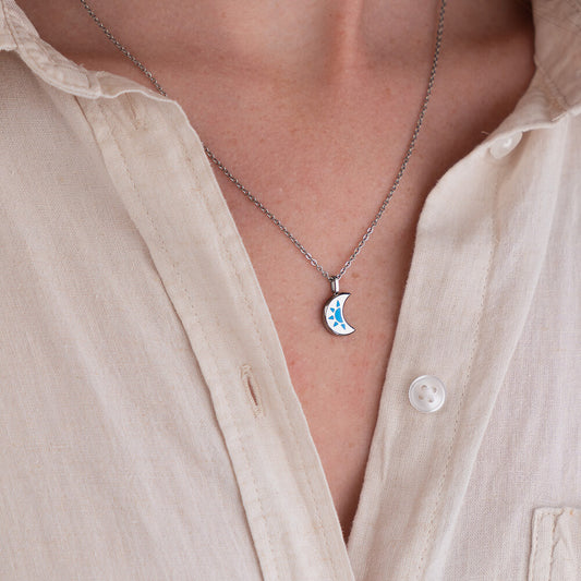 LUNA Necklace with a crescent moon pendant worn by a person in a light-colored shirt.