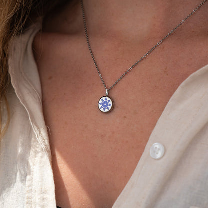 Silver SOLIS necklace with a silver pendant and purple sun detail worn by a person